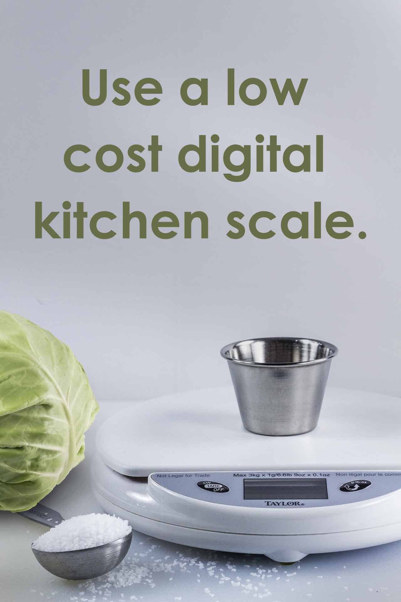 a digital kitchen scale with tablespoon of salt with a head of cabbage.